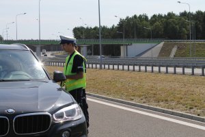 Policjant Krystian Kryś w trakcie kontroli pojazdu