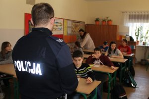 Policjant prowadzący wykład w klasie  dla dzieci
