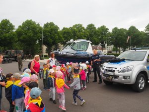 dzieci oglądają łódź policyjną  i  radiowóz