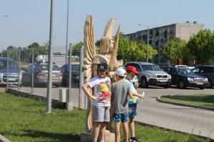 dzieci przy drewnianej rzeźbie