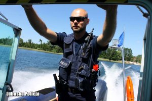 policjant podczas patrolu łodzią po jeziorze