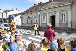 policjantka pomaga dzieciom przejść przez jezdnię