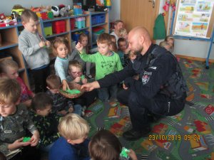 policjant wręcza dzieciom odblaski
