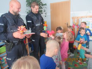 dzieci wręczają policjantom kwiaty