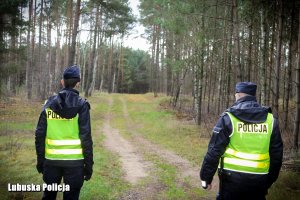 policjanci przy ścieżce w lesie