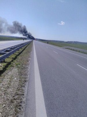fragment drogi ekspresowej oraz palący się samochód w oddali