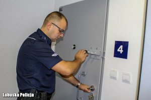 policjant zamyka drzwi od celi