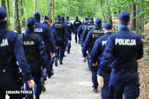 szpaler policjantów w lesie