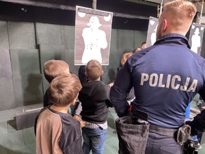 policjant pokazuje dzieciom strzelnice